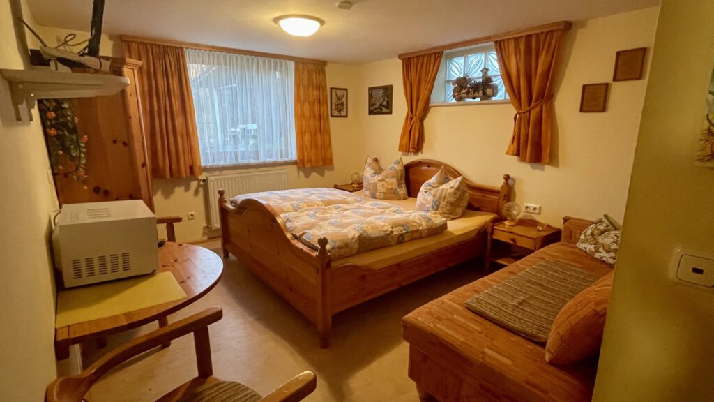 Doppelzimmer mit Holzbett und Sitzecke