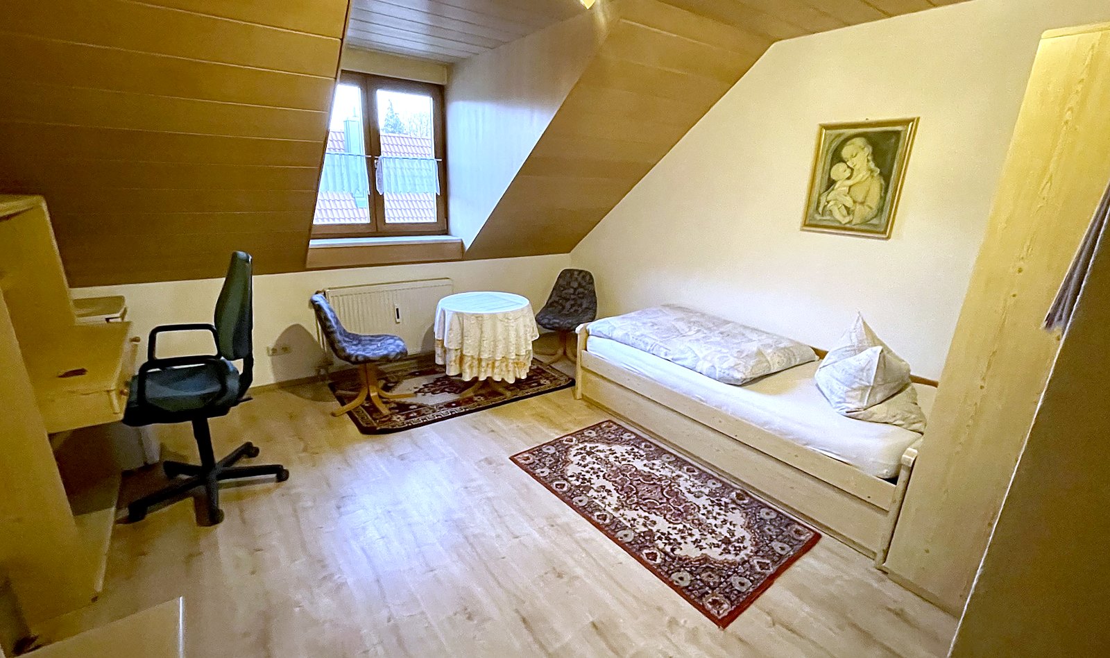 Zimmer mit Schreibtisch und Dachfenster