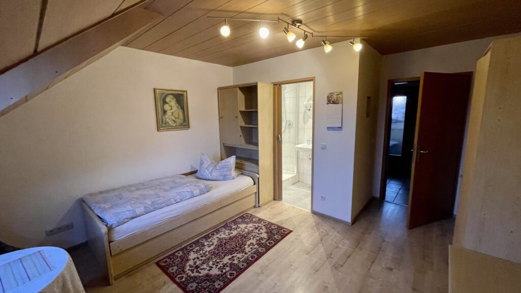 Zimmer mit Einzelbett und Teppich